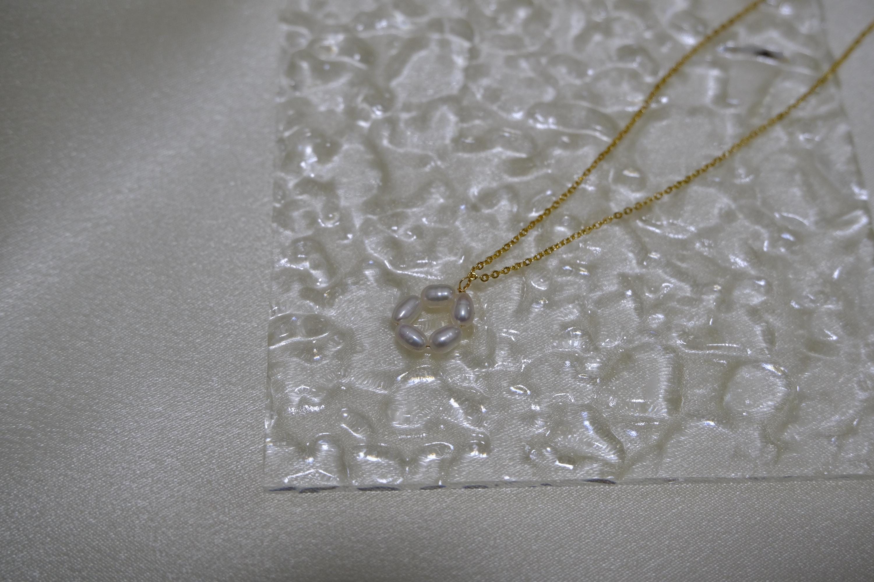 CAELLIA gold plated necklace featuring a delicate flower pendant made of small freshwater pearls.