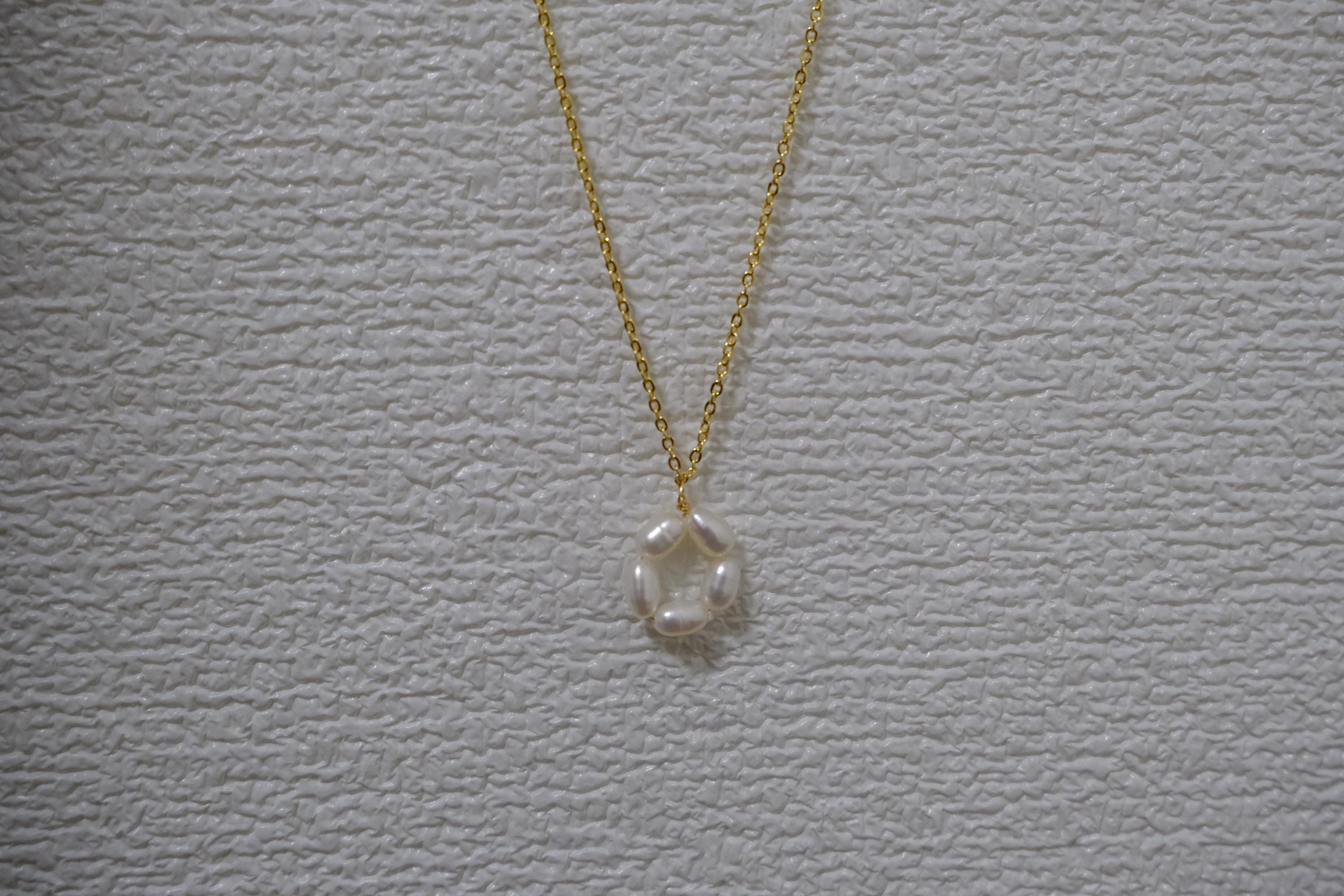CAELLIA gold plated necklace featuring a minimalist flower pendant made of freshwater pearls.