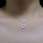 A CAELLIA gold plated necklace featuring a minimalist flower pendant made of freshwater pearls.