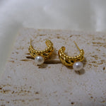 Caellia 14K gold huggie hoop earrings featuring a textured finish and a freshwater pearl.