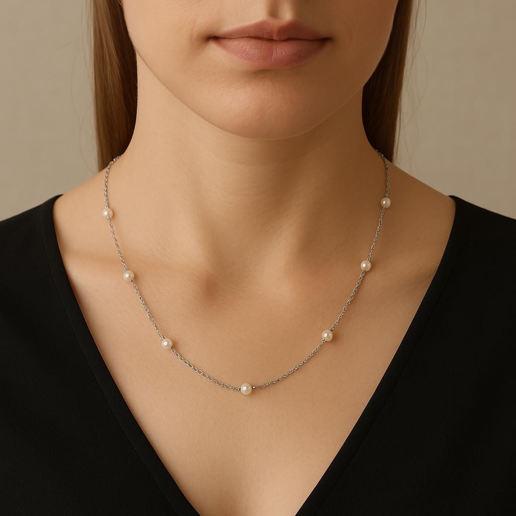 A woman wearing a Caellia sterling silver necklace featuring spaced freshwater pearls.