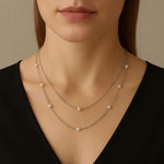 A model wears a Caellia sterling silver layered necklace featuring delicate freshwater pearls.