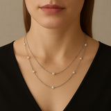 A model wears a Caellia sterling silver layered necklace featuring delicate freshwater pearls.