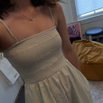 A person wears a dainty CAELLIA freshwater pearl pendant necklace with a bow detail.