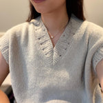 A woman wears CAELLIA butterfly bow stud earrings crafted with small freshwater pearls.