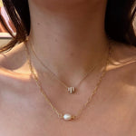 A model wears the Caellia 18K gold paperclip chain necklace featuring a baroque freshwater pearl.