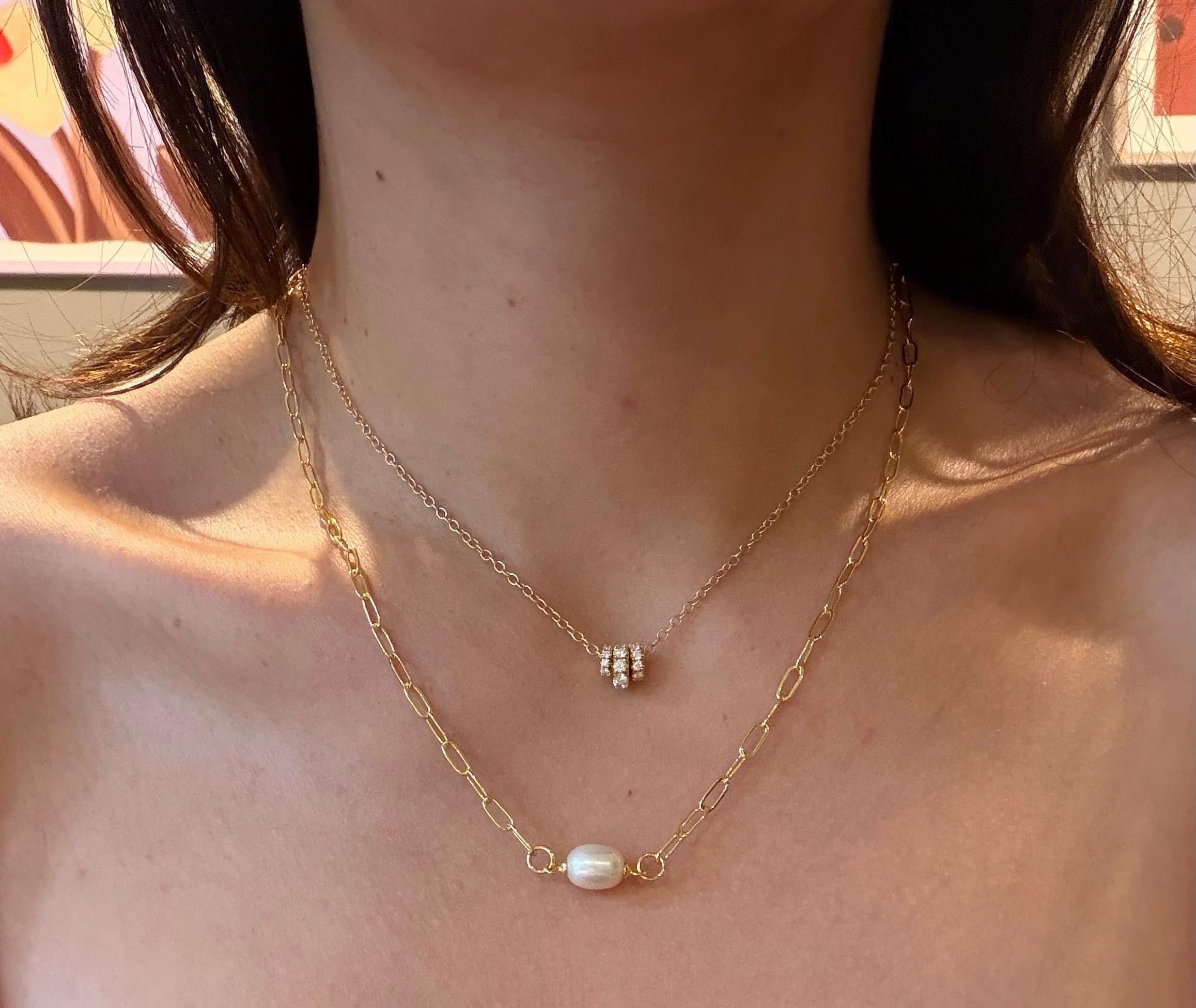 A model wears the Caellia 18K gold paperclip chain necklace featuring a baroque freshwater pearl.