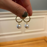 Caellia 18K gold hoop earrings featuring a single dangling freshwater pearl.