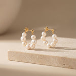 Caellia 18K gold hoop earrings featuring a delicate row of freshwater pearls.