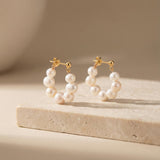 Caellia 18K gold hoop earrings featuring a delicate row of freshwater pearls.