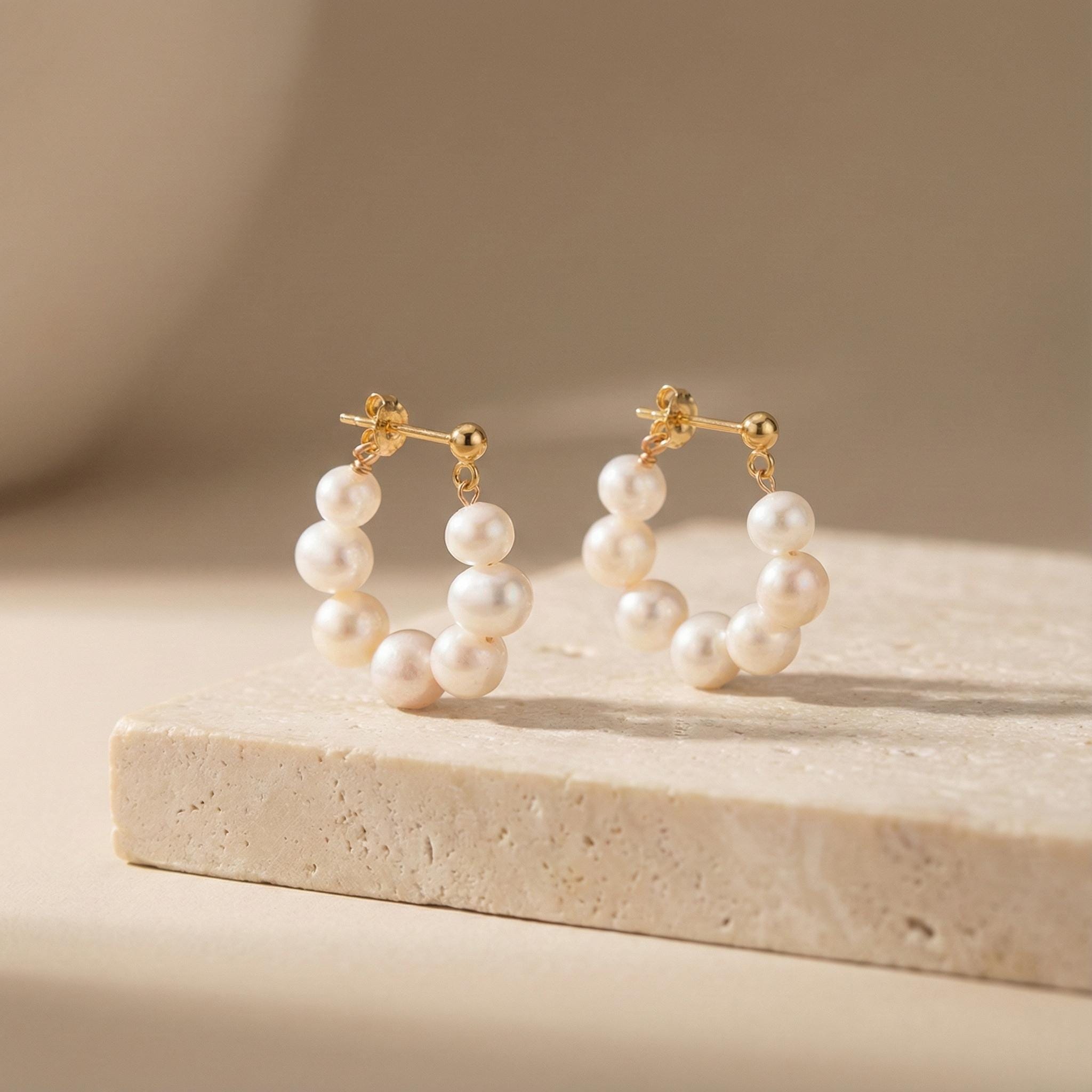 Caellia 18K gold hoop earrings featuring a delicate row of freshwater pearls.