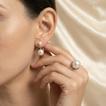 A model wears Caellia sterling silver double freshwater pearl stud earrings.