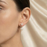 A model wears Caellia sterling silver double freshwater pearl stud earrings.