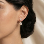 A model wears Caellia sterling silver double freshwater pearl stud earrings.