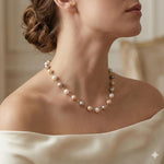 A Caellia freshwater pearl station necklace featuring champagne, grey, and white pearls on gold.
