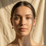 A woman wearing Caellia 14K gold plated sterling silver teardrop pearl earrings.