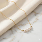 Caellia 18k gold dainty choker necklace featuring three freshwater pearls on a delicate chain.