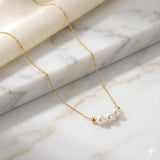 Caellia 18k gold dainty choker necklace featuring three small freshwater pearls.