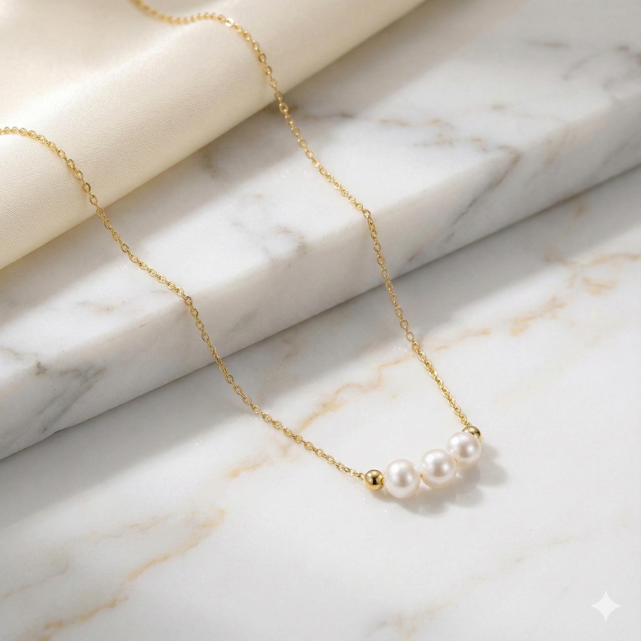 Caellia 18k gold dainty choker necklace featuring three small freshwater pearls.