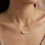 Caellia 18k gold dainty choker necklace featuring three lustrous freshwater pearls.