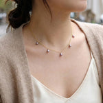 A woman wears a CAELLIA dainty lavender freshwater pearl choker on a 14K gold plated chain.
