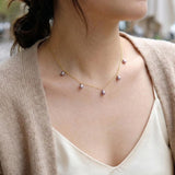 A woman wears a CAELLIA dainty lavender freshwater pearl choker on a 14K gold plated chain.
