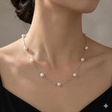 CAELLIA dainty freshwater pearl necklace with a 14K gold plated chain on a woman's neck.