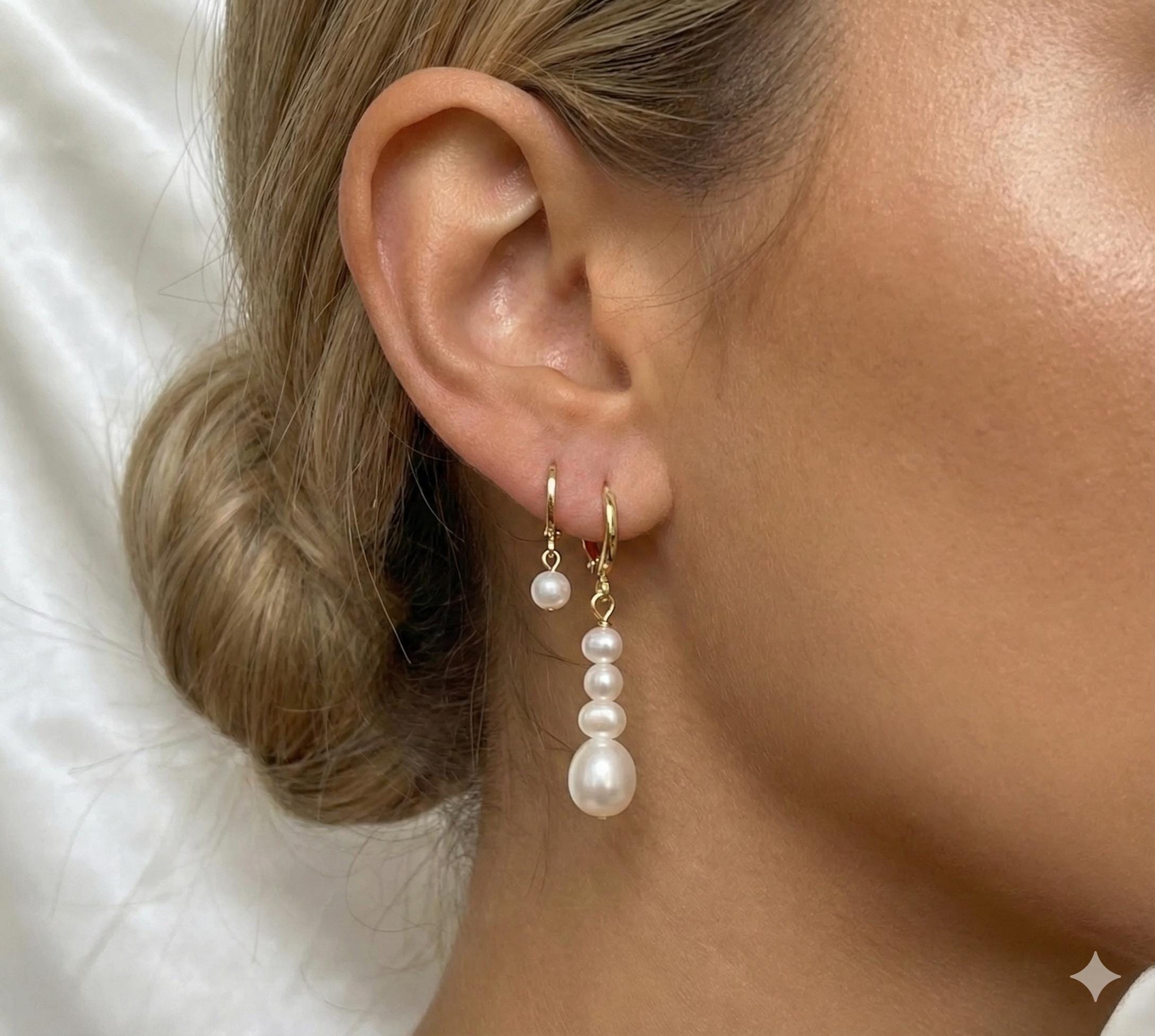 Caellia 14K gold hoop earrings featuring a single pearl and a cascading baroque pearl dangle.