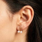 Caellia 14K gold music note stud earrings featuring two lustrous freshwater pearls.