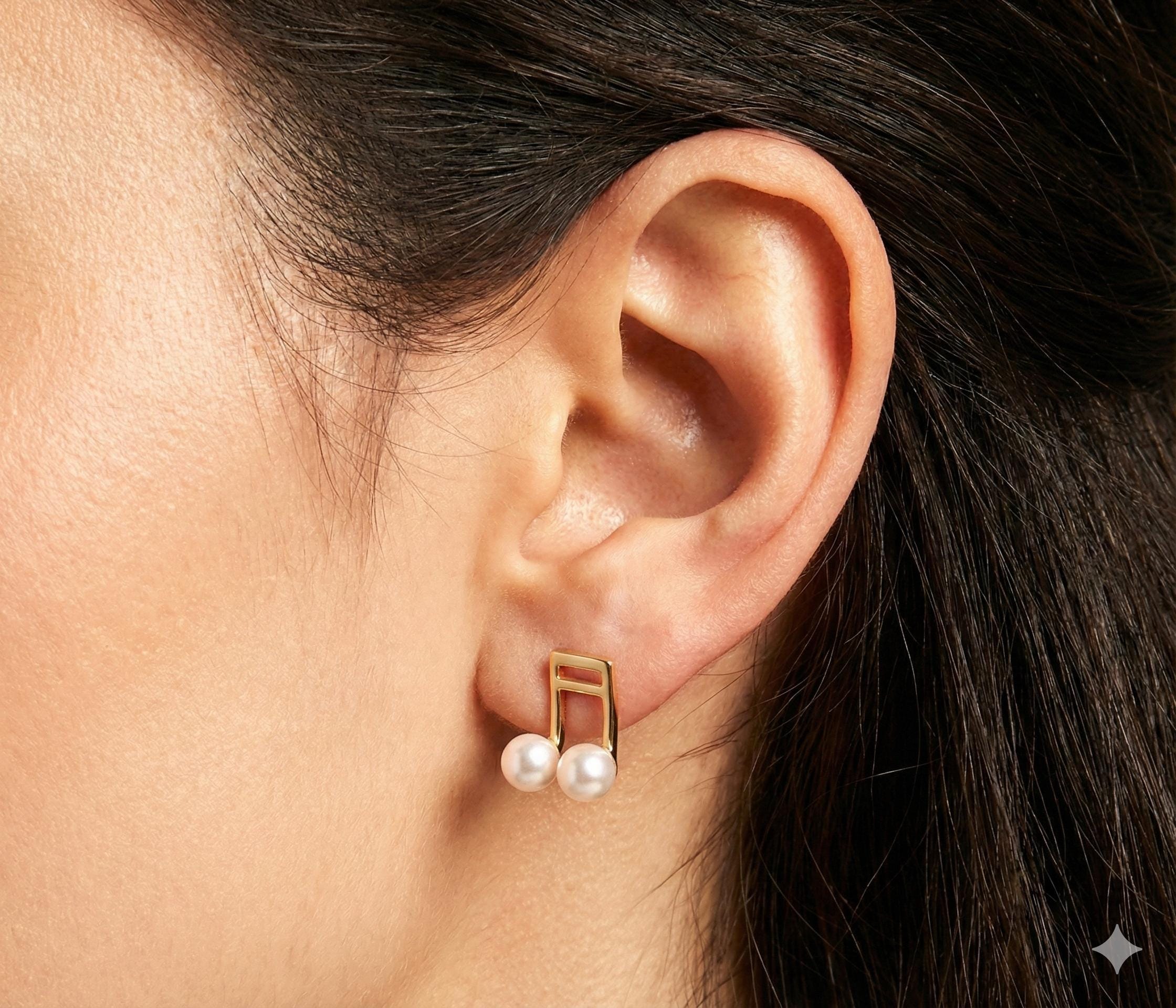 Caellia 14K gold music note stud earrings featuring two lustrous freshwater pearls.