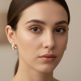 A woman wearing Caellia 14K gold filled freshwater pearl hoop earrings.