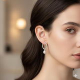 A model wears Caellia freshwater pearl drop earrings featuring a dainty gold hoop.