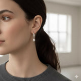 A woman wearing Caellia 14K gold freshwater pearl hoop earrings.