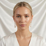 A model wears Caellia 14K gold hoop earrings featuring dangling baroque freshwater pearls.