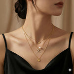 A model wears a layered gold Caellia necklace featuring a pave letter K pendant and a pearl.