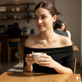 A woman wearing a Caellia 18k gold dainty freshwater pearl choker necklace.