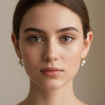A woman wearing Caellia 18K gold plated freshwater pearl stud earrings.