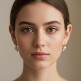 A woman wearing Caellia 18K gold plated freshwater pearl stud earrings.