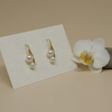 Caellia 18K gold plated stud earrings featuring two freshwater pearls on a display card.