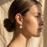 A woman wearing Caellia 14K gold plated sterling silver teardrop pearl earrings.