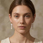 A model wears Caellia 14K gold triple freshwater pearl drop earrings.