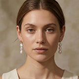 A model wears Caellia 14K gold triple freshwater pearl drop earrings.