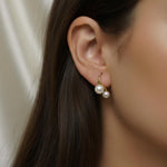 A model wearing Caellia 18K gold plated stud earrings featuring two freshwater pearls.