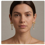 A model wearing Caellia 14K gold bow earrings with dangling freshwater pearls.
