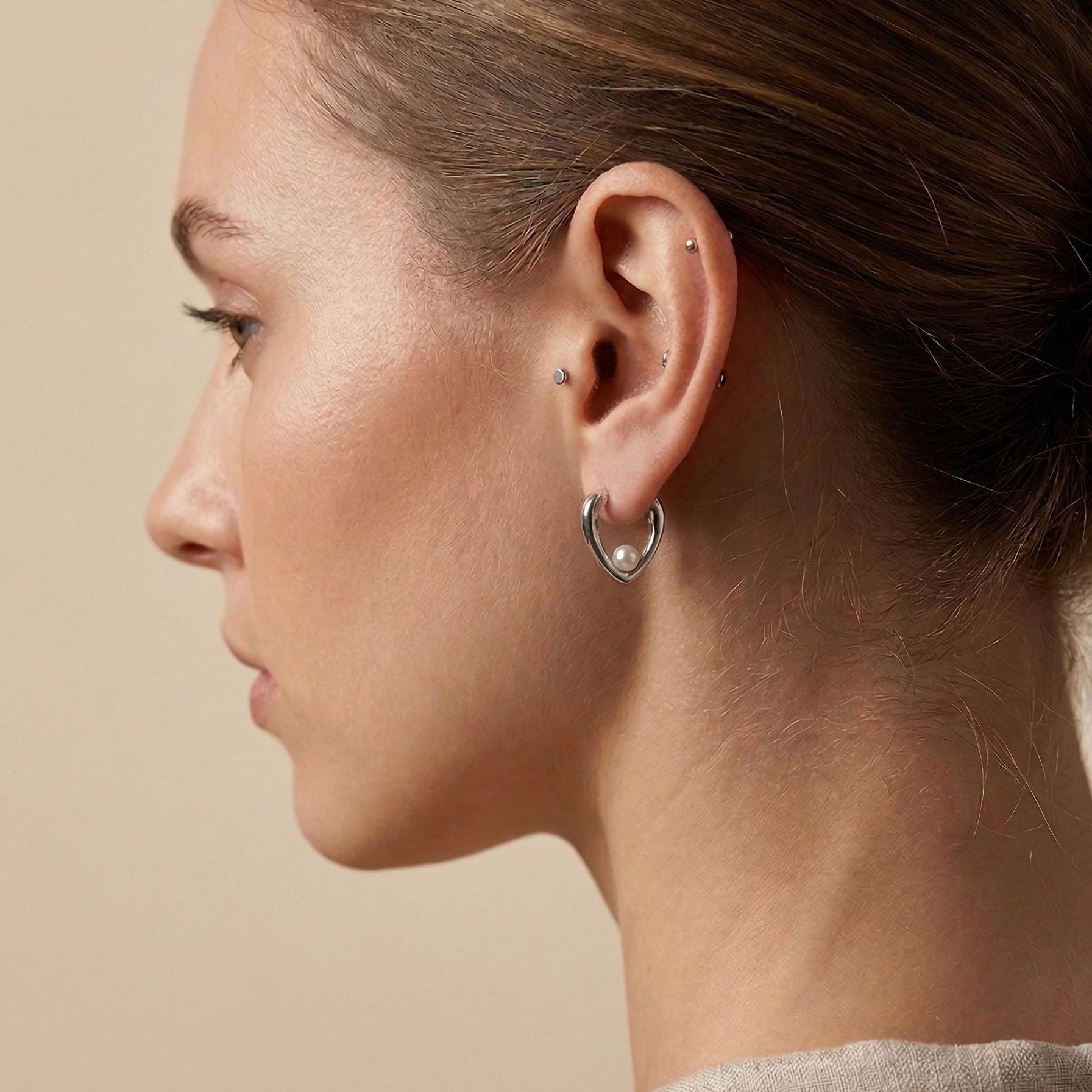 Freshwater pearl huggie hoop earrings showing 3D heart design detail