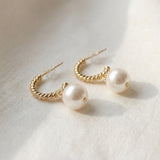 Close-up of twisted 14K gold plated sterling silver half hoops with pearl drops