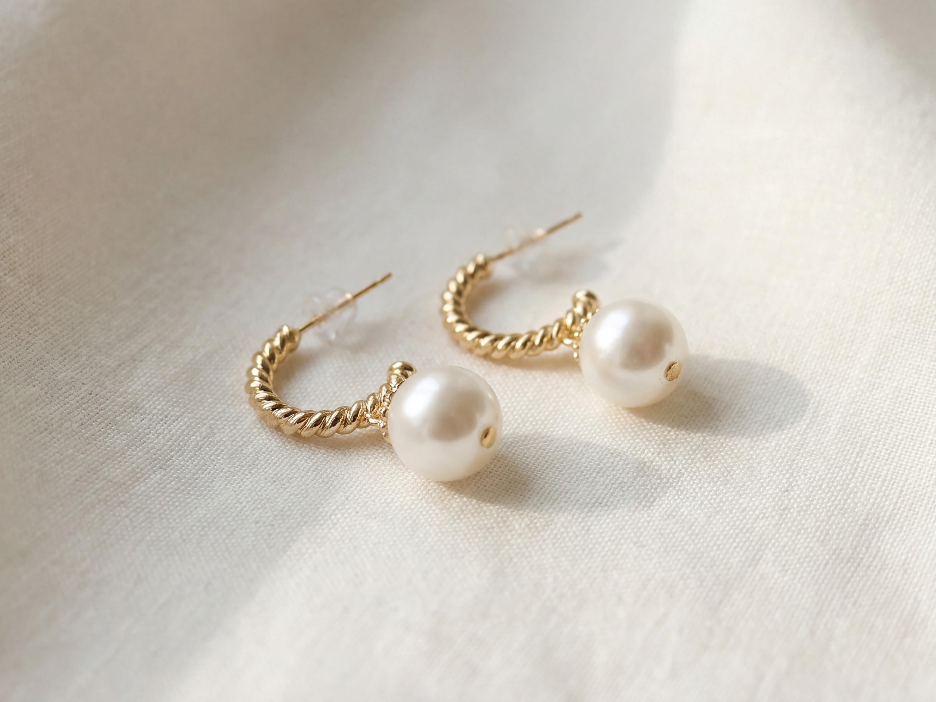 Close-up of twisted 14K gold plated sterling silver half hoops with pearl drops