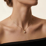 A model wears the Caellia 14K gold dainty freshwater pearl pendant necklace.