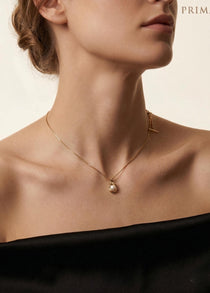 A model wears the Caellia 14K gold dainty freshwater pearl pendant necklace.