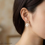 A woman wears the Caellia 14K gold bowknot earrings featuring a cluster of freshwater pearls.